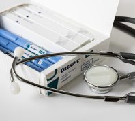 box of ozempic injectable pens alongside a stethoscope on a white background