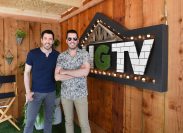 The Property Brothers, Drew and Jonathan Scott, posing for a photo in front of an HGTV sign