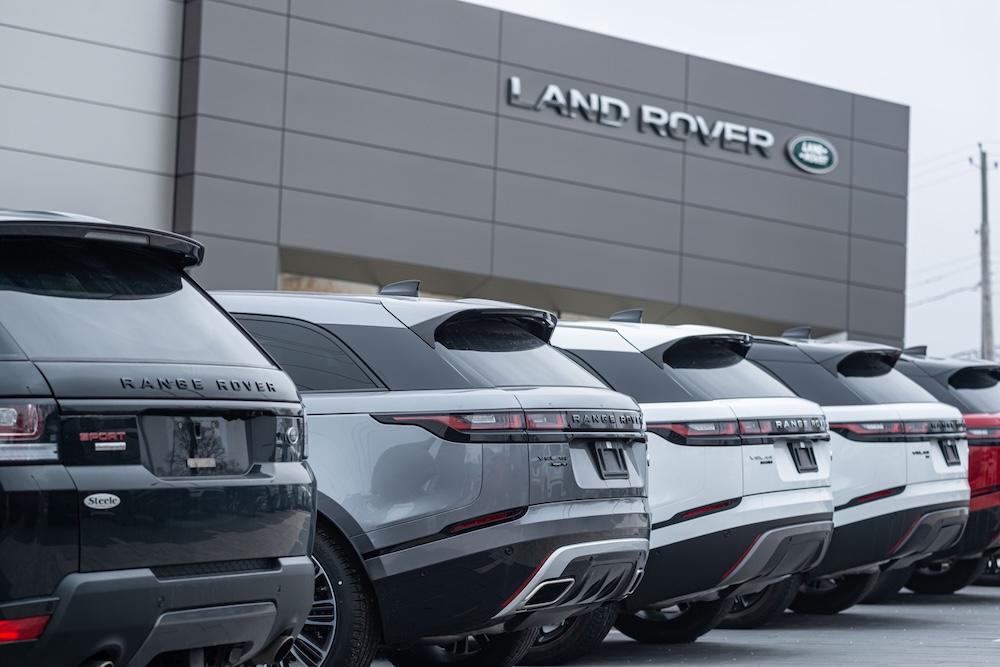 A row of Ranger Rovers parked in a Land Rover dealership.