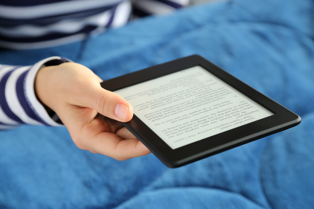 A person reading a Kindle e-reader