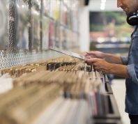 Man browsing through shelves at vinyl record store