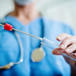 Close up of doctor with sample from sick woman. Selective focus on sample.