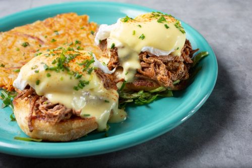 A closeup view of a plate of short ribs eggs Benedict.
