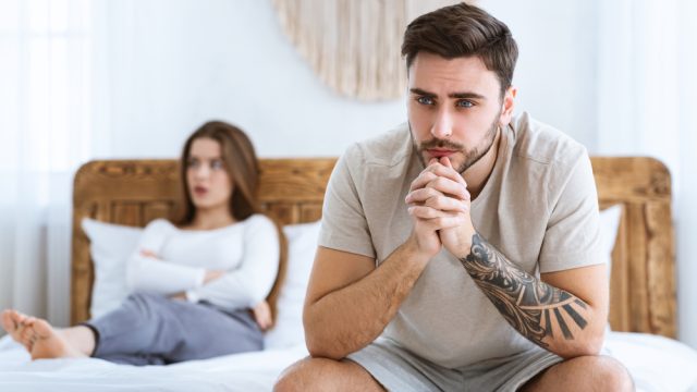 Unhappy young couple in bedroom