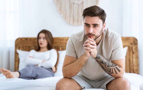 Unhappy young couple in bedroom