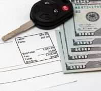 car repair bill with hundred-dollar bills and car key