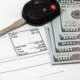 car repair bill with hundred-dollar bills and car key