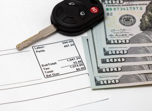 car repair bill with hundred-dollar bills and car key