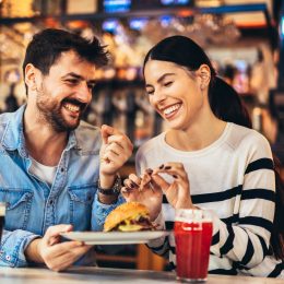 Young happy couple laughing on dinner date at restaurant