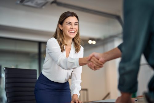 well-dressed woman shaking hands with manager