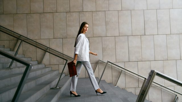 confident professional business woman walking downstairs