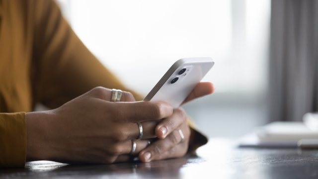 woman nervous thinking about sending text with phone in her hand