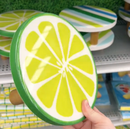 shopper holding up lime-shaped cake stand at Michaels