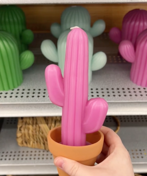 shopper holding up a pink cactus-shaped candle at Michaels