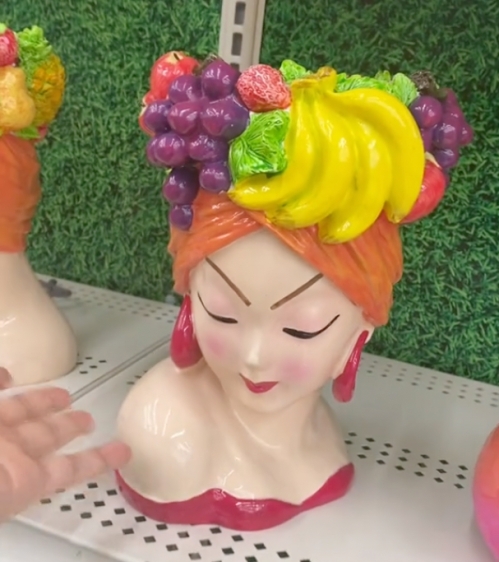 Woman with a fruit hat planter on a shelf