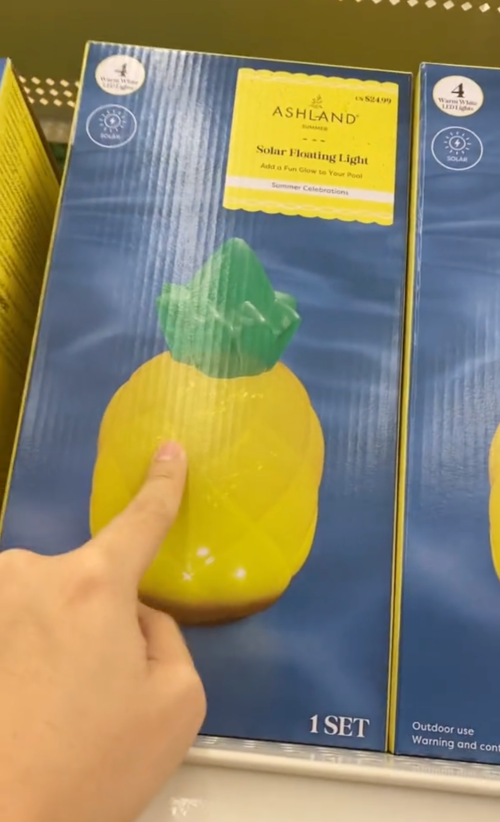 shopper pointing to a pineapple-shaped solar floating light at Michaels