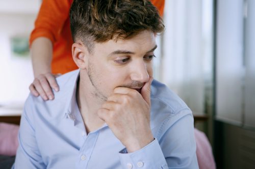 mother placing hand on her adult son's shoulder