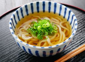 Udon noodle soup with scallions in blue and white bowl