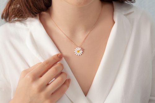A stylishly elegant 'love' necklace on the neck of the girl dressed in white