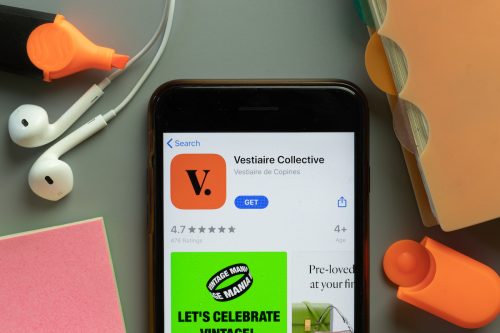 Vestiaire Collective mobile app icon on phone screen top view
