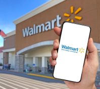Walmart retailer delivery application on smartphone holding by hand with blurry Walmart store in the background