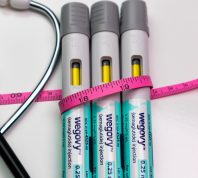 Wegovy auto injector pens with pink tape measure and stethoscope