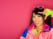 woman wearing 80s outfit voguing against pink background