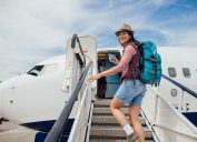A woman boarding a plane up a set of stairs