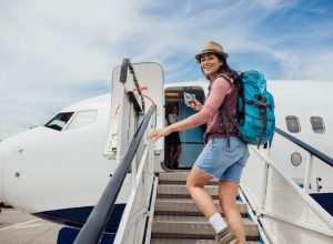 A woman boarding a plane up a set of stairs