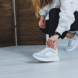 Woman kneeling down fixing her sneaker