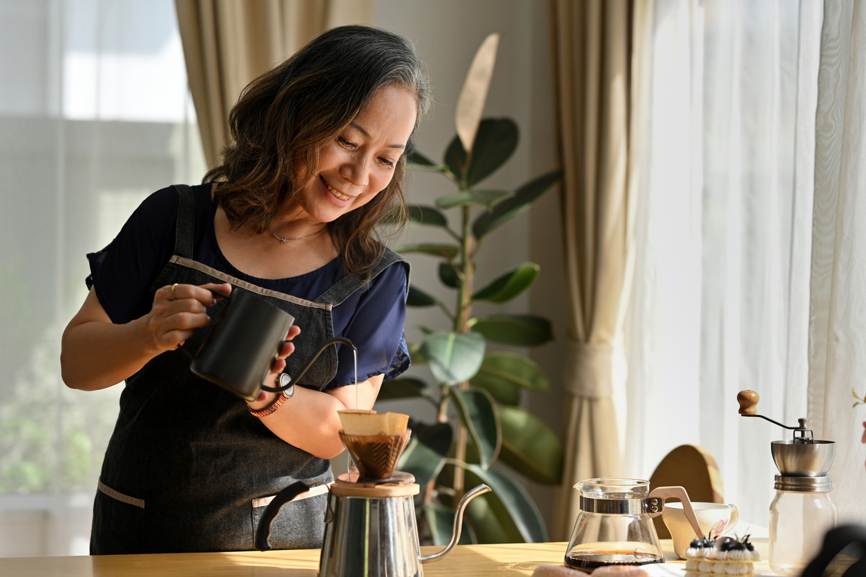 A woman making pour over coffee in her kitchen