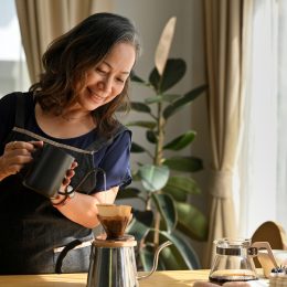 A woman making pour over coffee in her kitchen