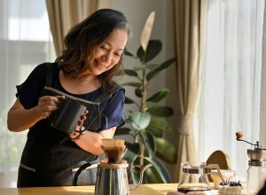 A woman making pour over coffee in her kitchen