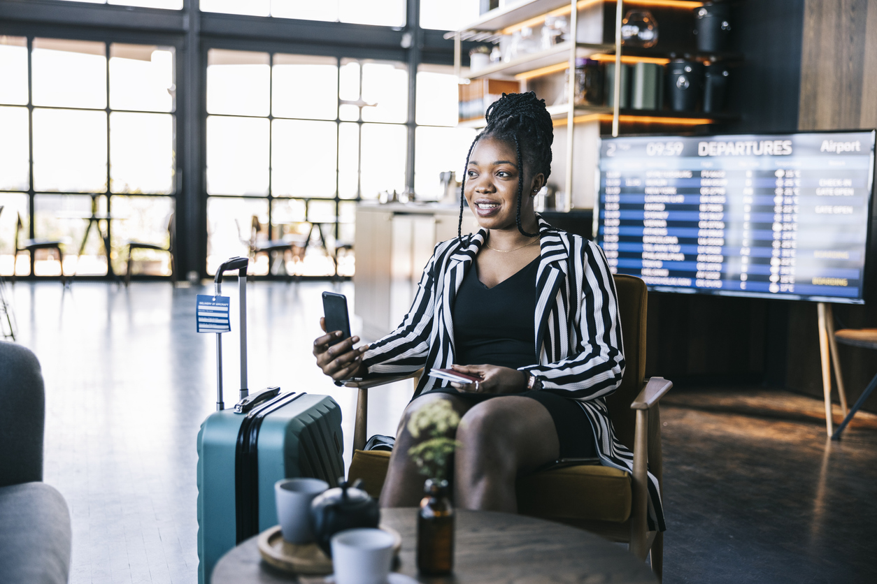 A woman taking a video call on her phone in an airport lounge