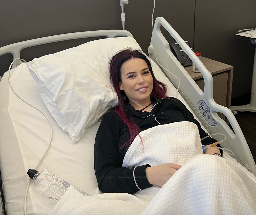 Anca Molnar smiling while laying in a hospital bed