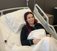 Anca Molnar smiling while laying in a hospital bed
