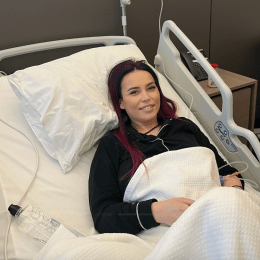 Anca Molnar smiling while laying in a hospital bed
