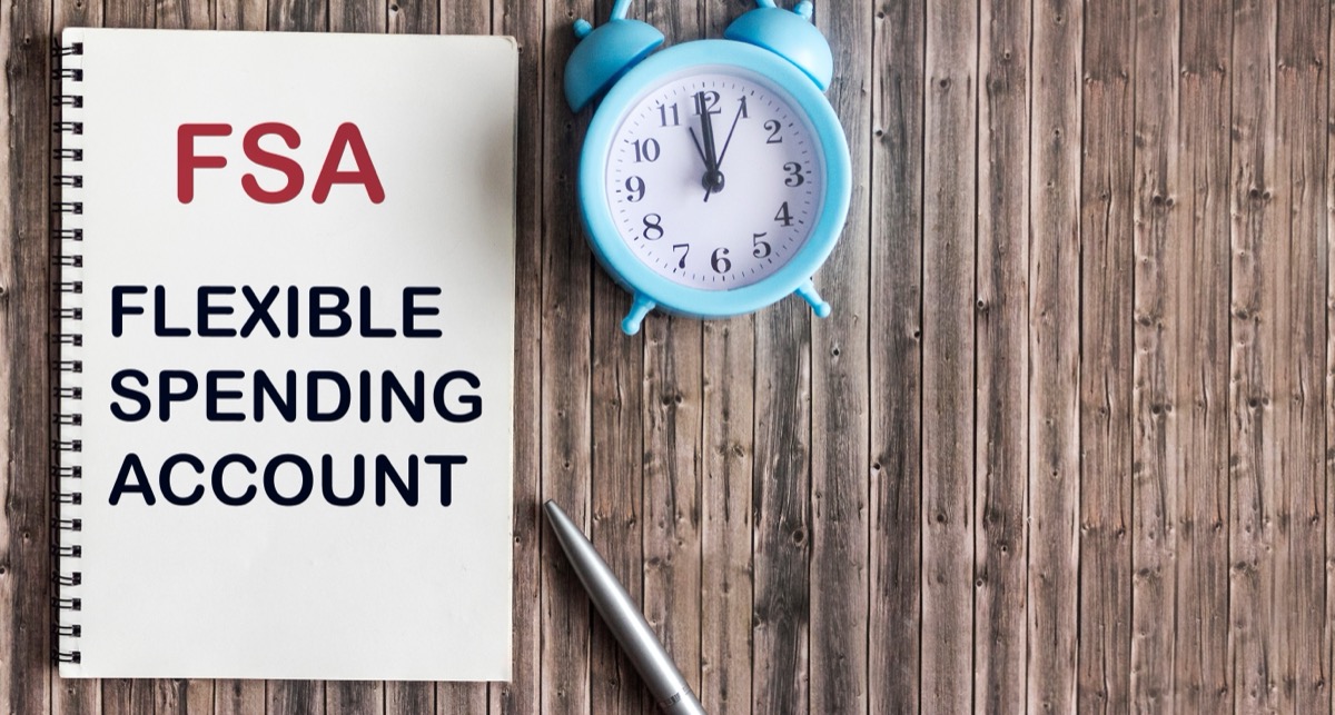 FSA flexible expense account sign on notepad and wooden background