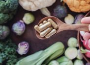 Supplements surrounded by gut healthy vegetables
