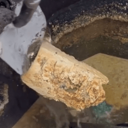 Still from a video showing a drain clogged with grease