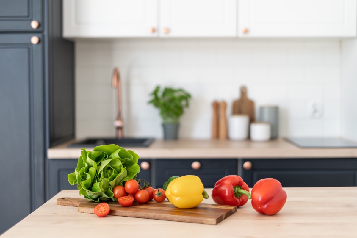 Contemporary kitchen interior design. Healthy food products on table. Salad ingredients. Cooking at home. Home comfort. Healthy nutrition and lifestyle