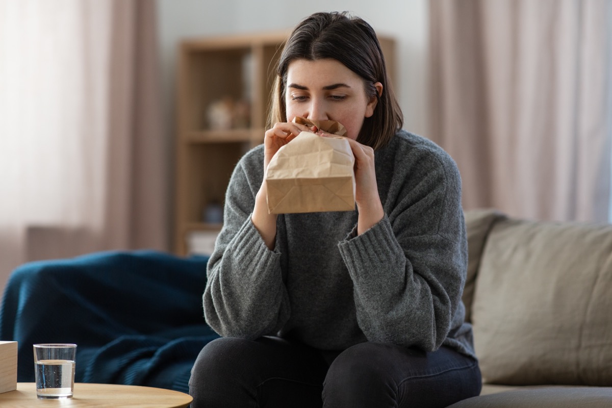 Woman breathing into paper bag