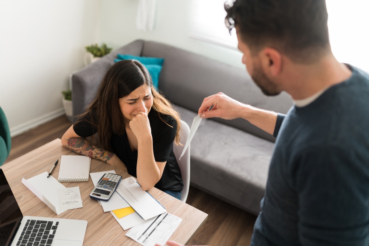 Sad young woman crying with her husband while doing their taxes because of their financial and money problems