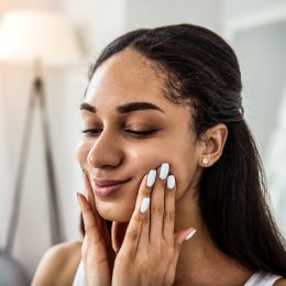 woman touching her cheeks doing face yoga