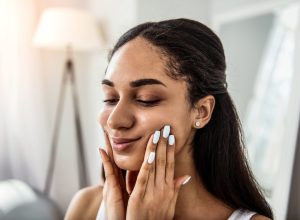 woman touching her cheeks doing face yoga