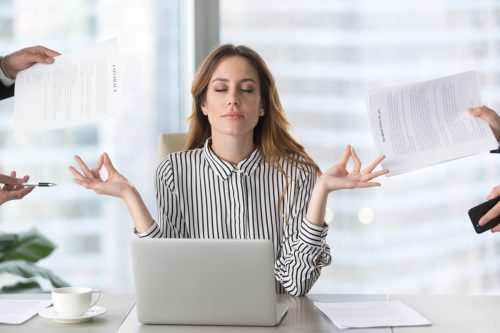 female executive meditating taking break at work