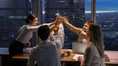 team giving a group high five at work