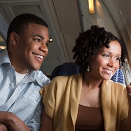 Man and woman on a plane pointing out the window