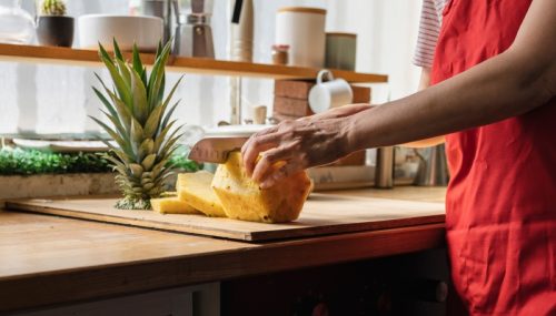 woman cutting pineapple rings