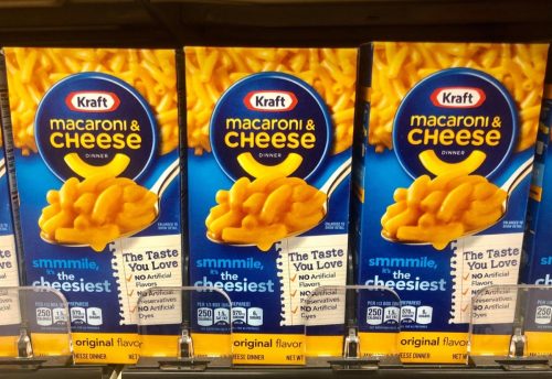 Several Boxes of Kraft Mac & Cheese on shelve at a grocery store .